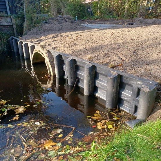 Beschoeiing met een duiker langs een watergang