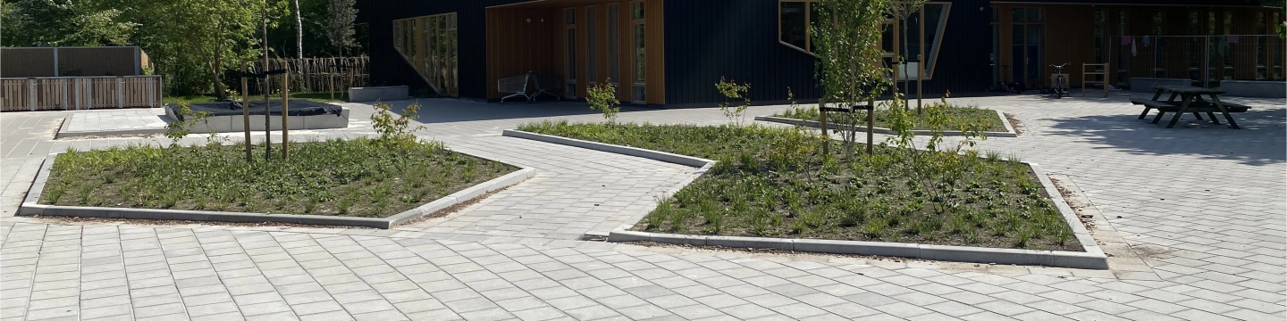 Bestrate paden en plantvakken bij een gebouw